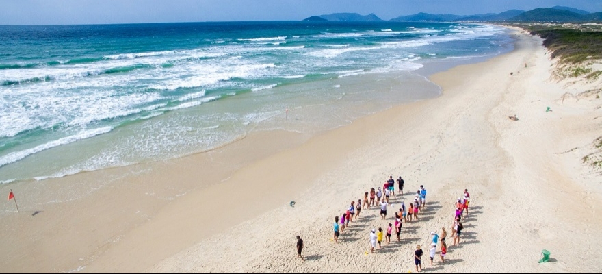 Juvenis fazem trabalhos físicos na Praia da Joaquina, em Florianópolis